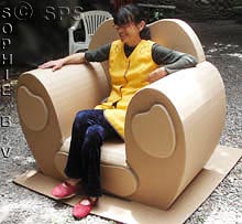 Sylvie installée dans un fauteuil en carton avec trois tiroirs