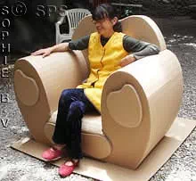 Sylvie installée dans un fauteuil en carton avec trois tiroirs